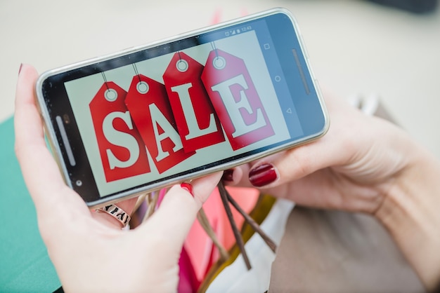 Mulher segurando smartphone com inscrição na tela