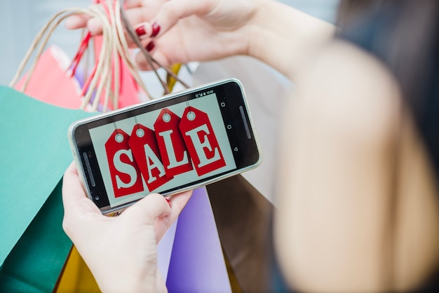 Foto grátis mulher segurando smartphone com inscrição na tela