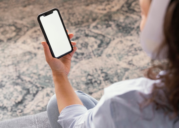 Mulher segurando smartphone de perto