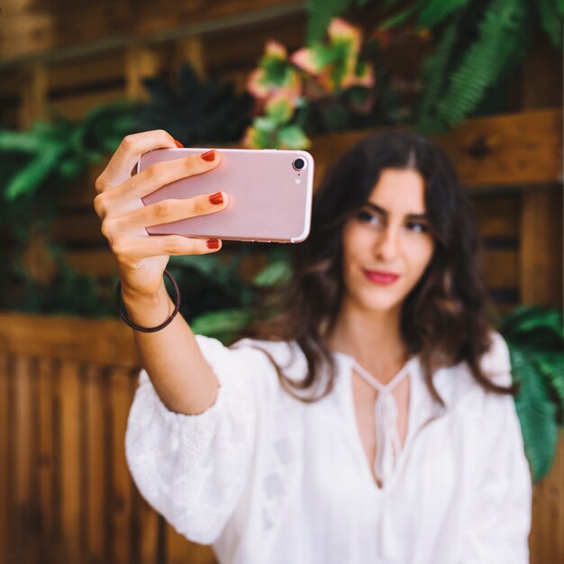 Mulher segurando smartphone para levar selfie