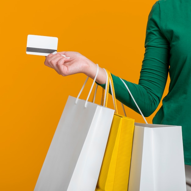 Foto grátis mulher segurando um cartão de crédito e muitas sacolas de compras