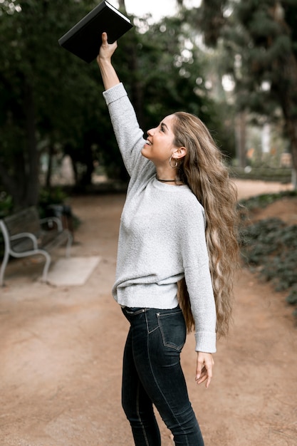 Foto grátis mulher segurando um livro lá fora