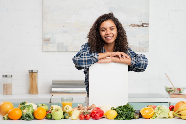 Foto grátis mulher segurando um mock up sinal ao lado de legumes