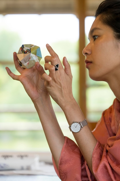 Foto grátis mulher segurando um objeto de origami