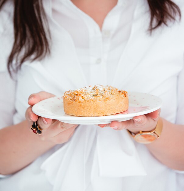 Mulher segurando um prato com torta de maçã