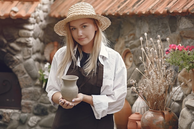 Mulher segurando um vaso artesanal