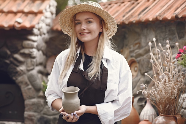 Mulher segurando um vaso artesanal