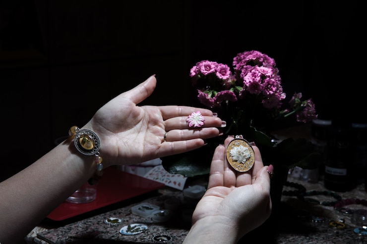 Foto grátis mulher segurando uma bijuteria floral dourada