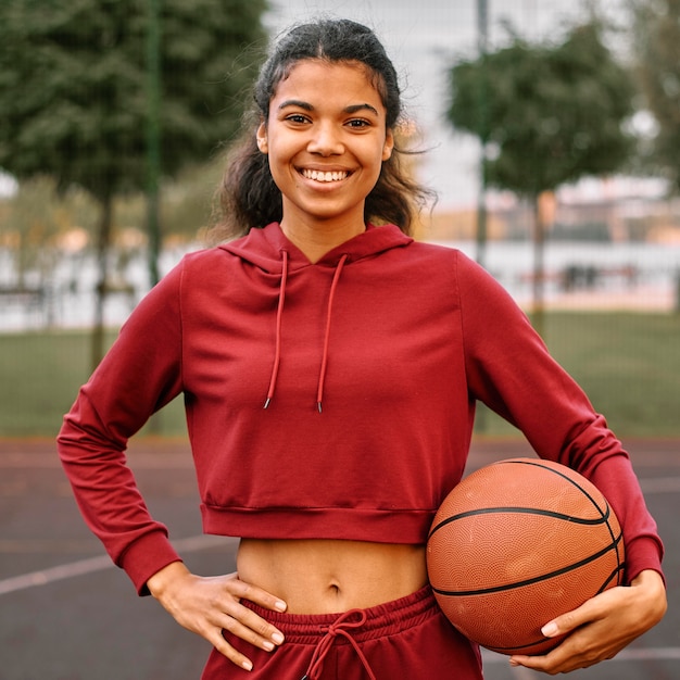 Foto grátis mulher segurando uma bola de basquete ao ar livre