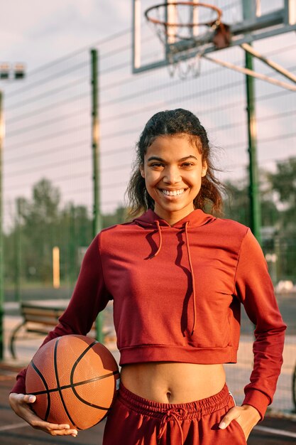 Mulher segurando uma bola de basquete ao ar livre