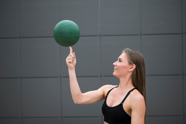 Foto grátis mulher segurando uma bola no dedo plano médio