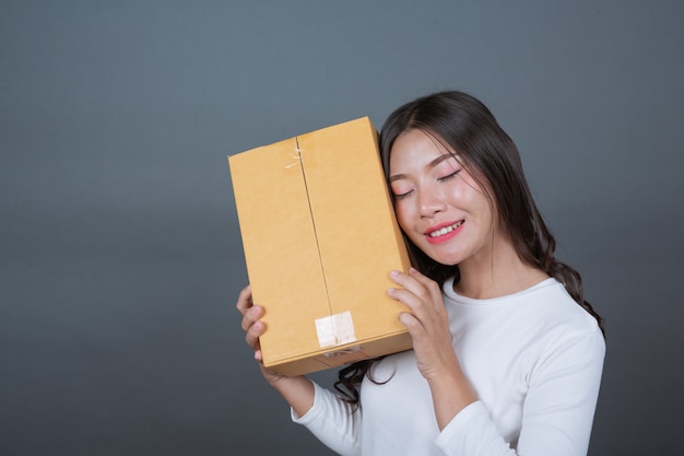 Mulher segurando uma caixa de correio marrom made gestos com linguagem gestual.