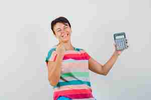 Foto grátis mulher segurando uma calculadora em uma camiseta listrada e parecendo feliz