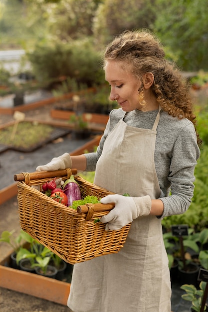 Mulher segurando uma cesta de legumes, tiro médio