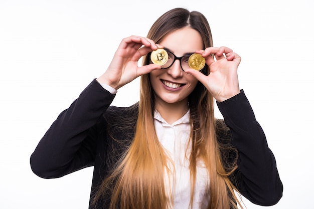 Mulher segurando uma criptomoeda física de moeda bitcoin na mão na frente dos olhos