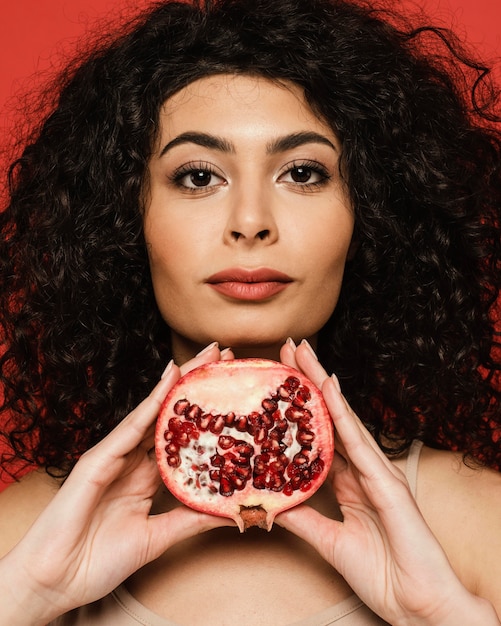 Foto grátis mulher segurando uma romã em close-up