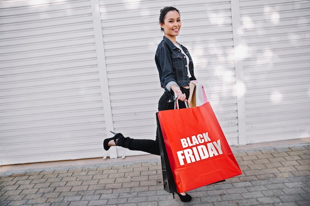 Mulher segurando uma sacola preta de compras na sexta-feira