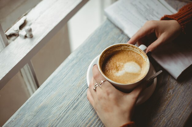 Mulher segurando uma xícara de café