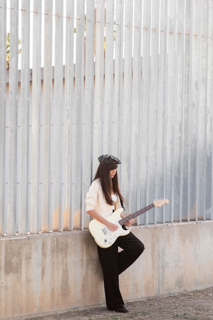 Mulher segurando violão em um tiro completo