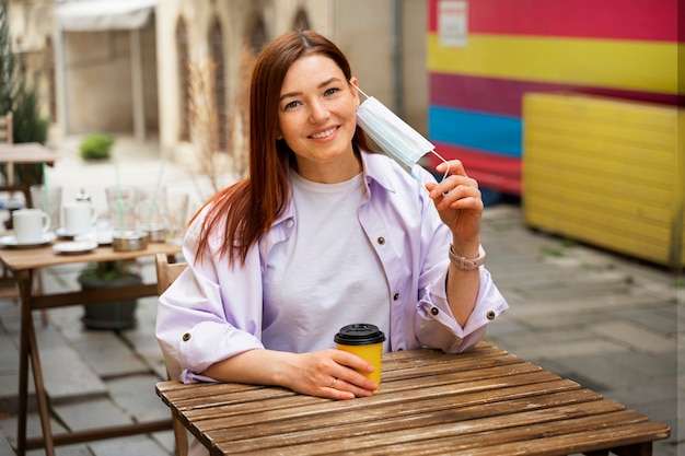 Mulher segurando xícara de café dose média