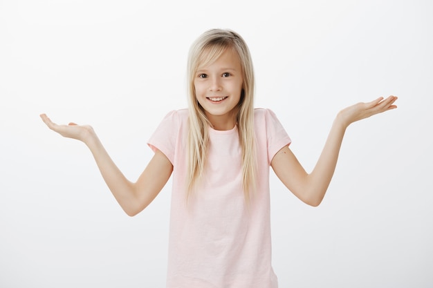 Mulher sem noção dando de ombros não sabe de nada e sorrindo