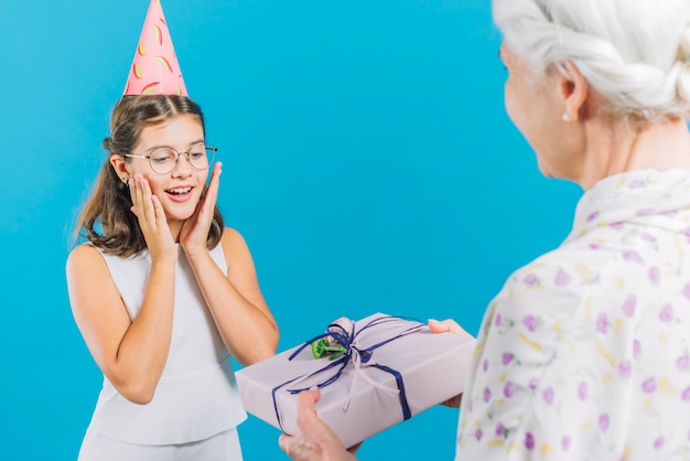 Mulher sênior, dar, presente aniversário, para, dela, neta, ligado, experiência azul