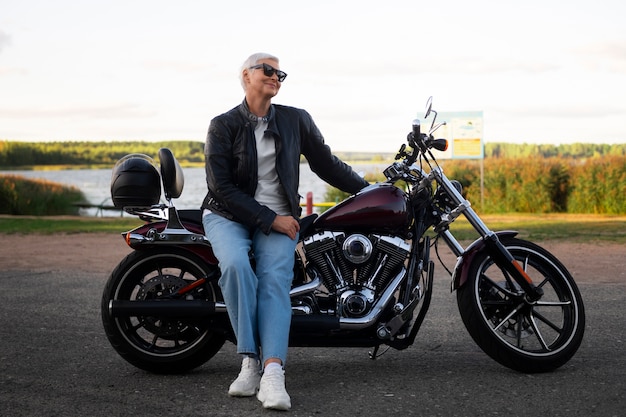 Mulher sênior de tiro completo com motocicleta