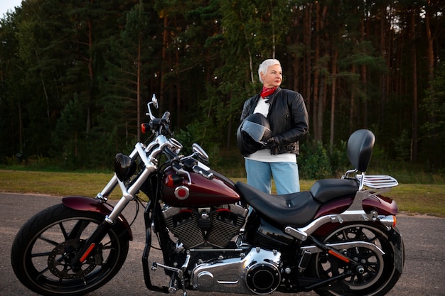 Mulher sênior de tiro completo com motocicleta