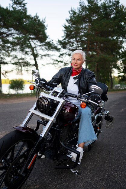 Mulher sênior de tiro completo com motocicleta