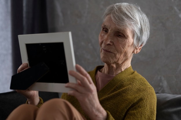 Foto grátis mulher sênior de tiro médio olhando para a foto