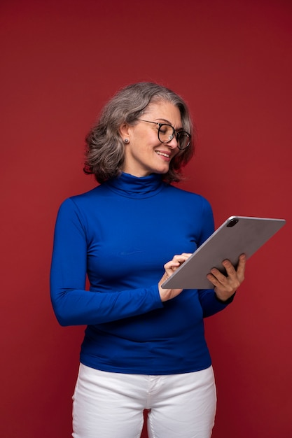 Mulher sênior de tiro médio segurando tablet