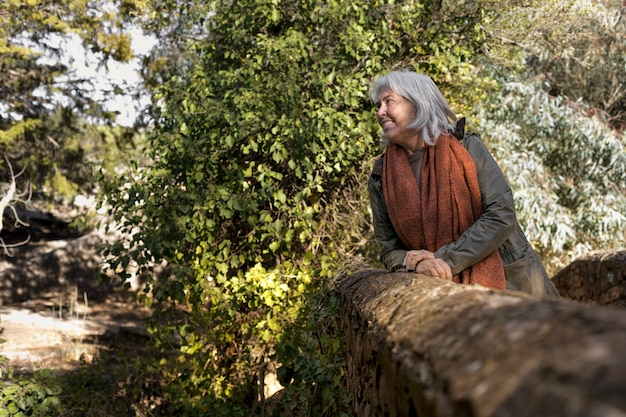 Foto grátis mulher sênior, desfrutando de uma caminhada na natureza