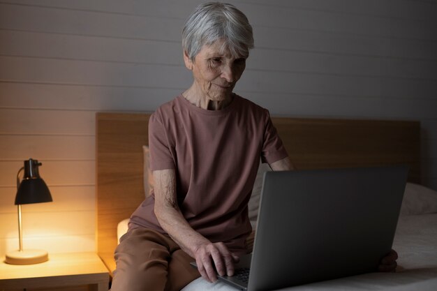 Mulher sênior em tiro médio com laptop