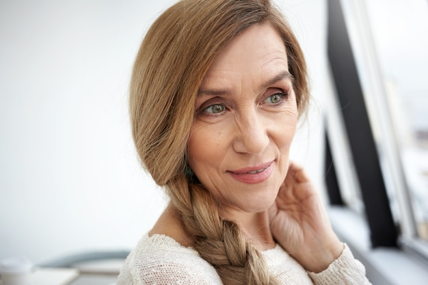 Mulher sênior expressiva posando em ambiente fechado