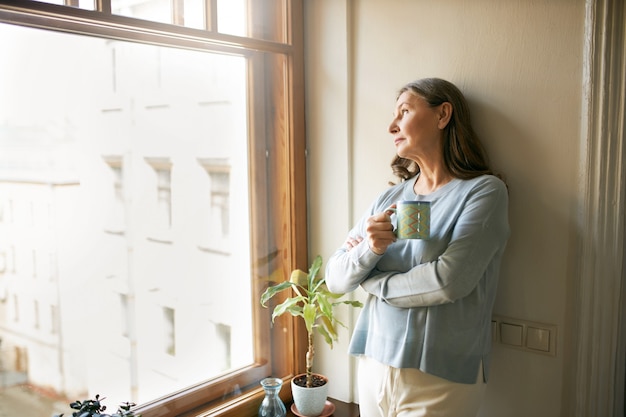 Foto grátis mulher sênior expressiva posando em ambiente fechado