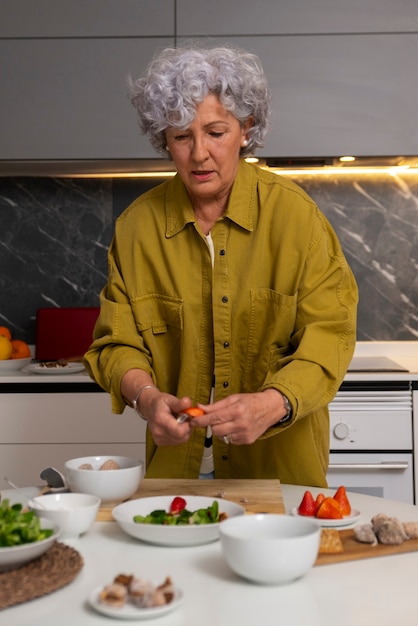 Foto grátis mulher sênior fazendo prato com figos na cozinha