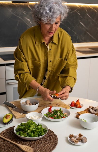 Foto grátis mulher sênior fazendo prato com figos na cozinha