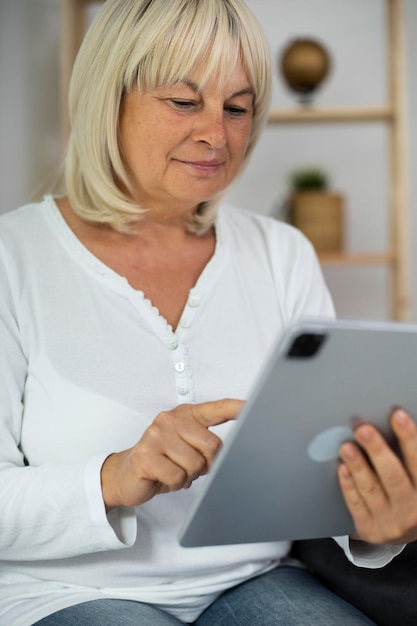 Mulher sênior fazendo uma aula online em seu tablet