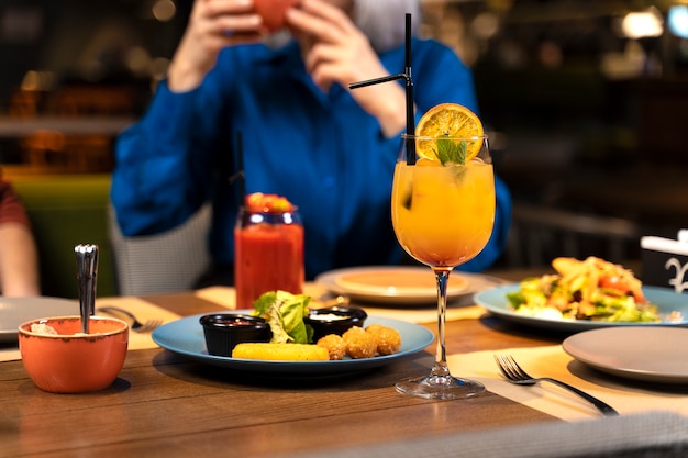 Foto grátis mulher sênior tirando foto de comida e bebidas no restaurante