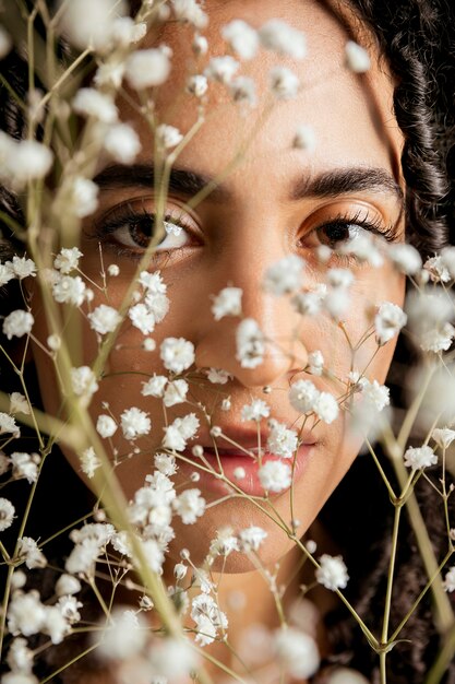 Mulher sensual por trás dos galhos de flores