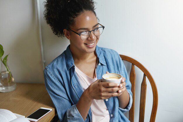 Mulher sentada à mesa com café