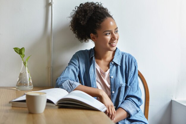 Mulher sentada à mesa com um livro