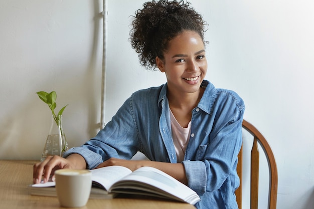 Mulher sentada à mesa com um livro