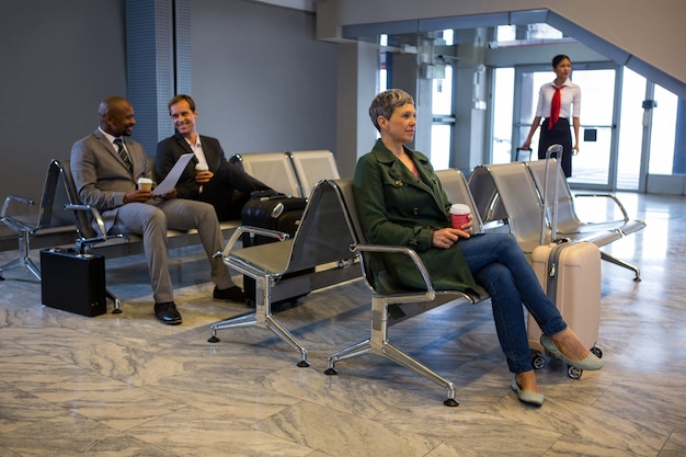 Mulher sentada com bagagem na sala de espera