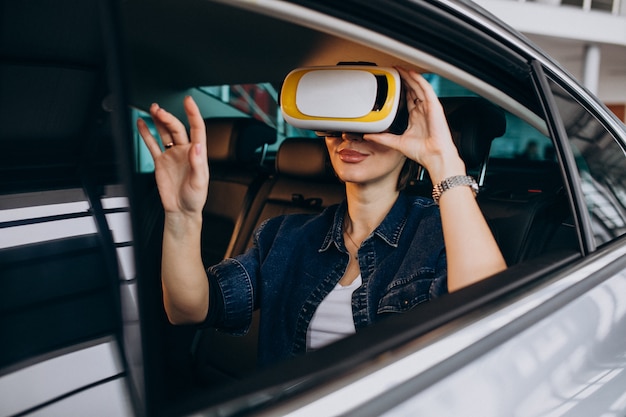 Mulher sentada dentro de um carro usando óculos vr