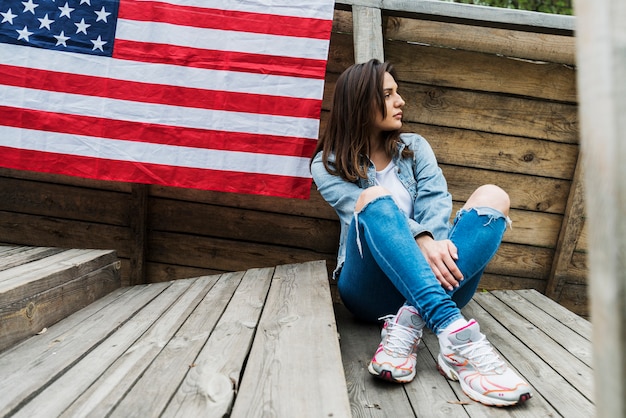 Foto grátis mulher sentada e bandeira americana