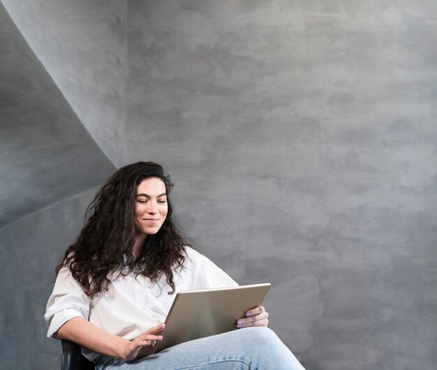 Mulher sentada e olhando para o laptop
