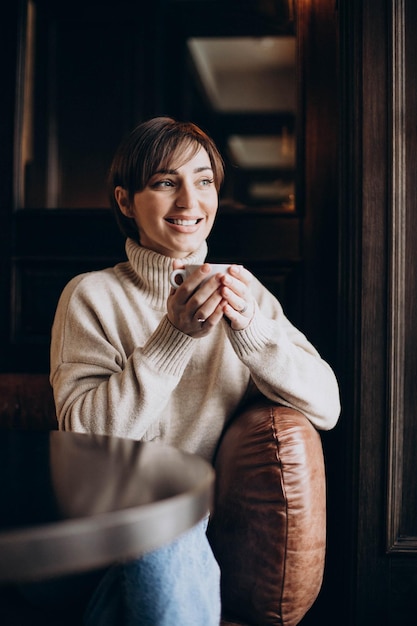 Mulher sentada em um café e tomando café