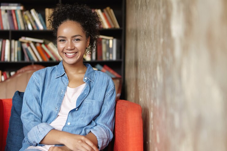 Foto grátis mulher sentada em uma biblioteca em um sofá