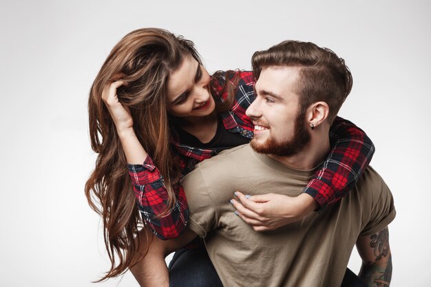 Foto grátis mulher sentada nas costas do homem se divertindo, olhando para ele.